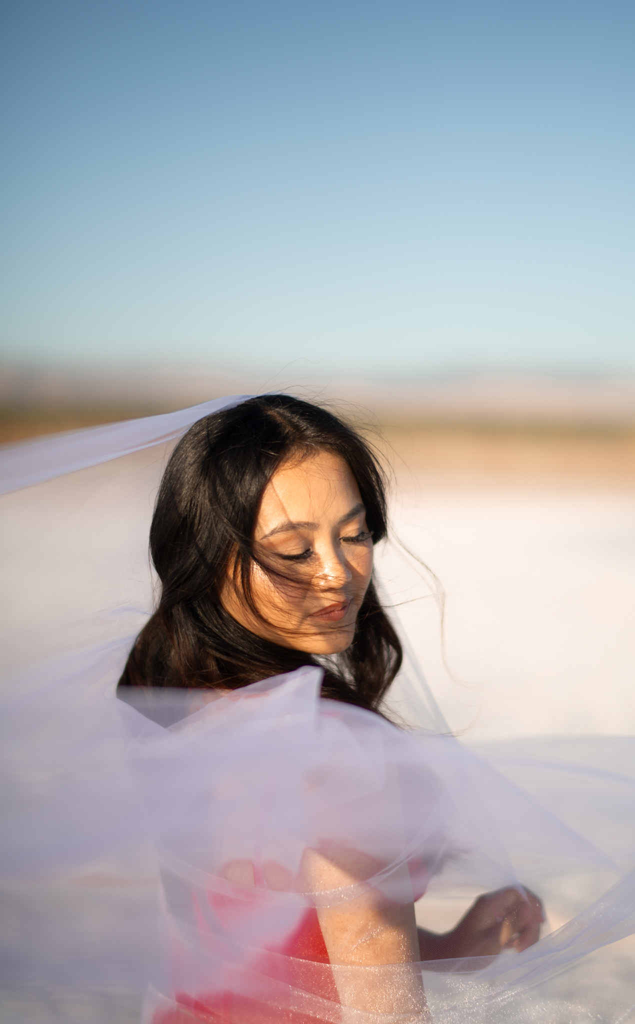 Creative windswept portrait wrapped in translucent fabric